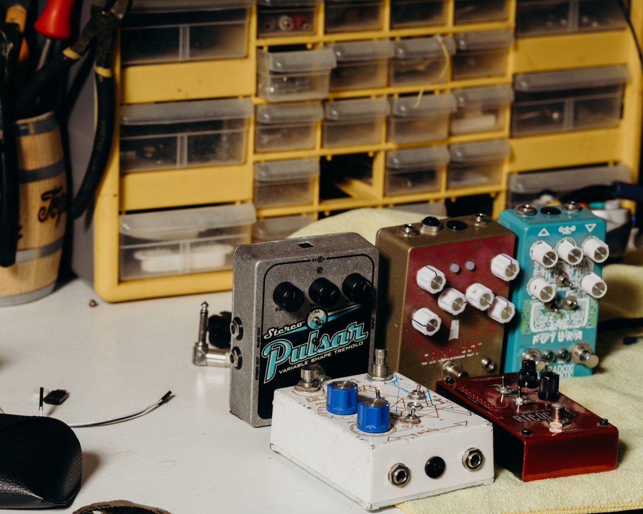 Home Close-up of various guitar effects pedals organized on a workbench. Ideal for music tech concepts.