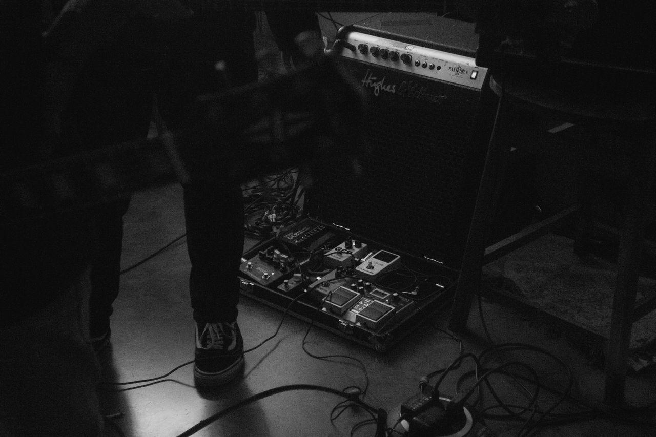 Home Black and white photo of a guitar setup with effects pedals, perfect for music enthusiasts.