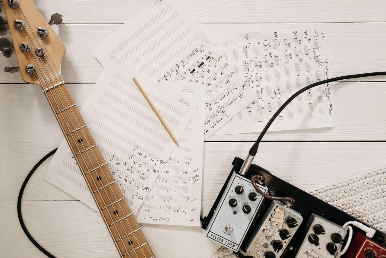 Offerings Bass guitar and music equipment arranged on a white surface, showcasing creative music setup.